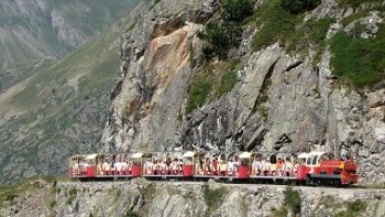 METTRE EN PLEIN ECRAN, c'est magnifique !

Cette voie a été construite à plus de 2000 mètres d'altitude par la SNCF dans le cadre des travaux d'électrification de son réseau. Elle a servi à la construction du barrage que l'on voit dans le film. Ce barrage alimente par des conduites forcées la centrale située dans la vallée. Grâce au tunnel, la voie passe d'une première vallée dans une seconde. On peut admirer les très beaux plissements de la montagne. C'est une des plus belles promenades des Pyrénées.