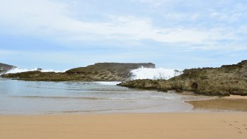  plage de Playa Puerto Nuevo à Vega Baja, Puerto Rico..
Une grande barre rocheuse naturelle familièrement appelée "La Peña" abrite la plage de la haute mer.
Par grosse mer, les vagues énormes de l'Océan Atlantique Nord tapent contre la barrière rocheuse, l escaladent et retombent le long de la paroi rocheuse, enchantant les baigneurs.