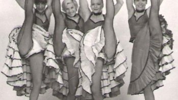 " Une danse folle et obscène " à laquelle on se livre " avec emportement ". C'est ainsi qu'Eugène Sue évoquait le "chahut", l'ancêtre du French Cancan, dans Les Mystères de Paris en 1843. Cinquante ans plus tard, le cancan était toujours aussi mal vu, mais incroyablement plus populaire. On vous raconte la sulfureuse histoire qui se cache derrière cette danse, indissociable des femmes de la Belle Époque. - DE LA QUADRILLE AU "CHAHUT" - L'histoire du cancan français débute dans les années 1820. À cette époque, la quadrille est la danse en vogue dans les bals publics de la capitale. Mais, si populaire soit-elle, cette danse en groupe présente un défaut de taille : il n'y a aucune place pour l'improvisation. En effet, la chorégraphie s'effectue systématiquement en couple et les figures sont exécutées dans un ordre quasi-canonique. Lassés de ne pouvoir se permettre quelques audaces en groupe, des hommes décident de s'octroyer quelques minutes d'extravagance en solo. Ces minutes de "chahut" à base de figures désordonnées et de mouvements anarchiques deviennent très vit des séances cathartiques pour les hommes qui s'adonnent à ce menu plaisir. Les réactions sont contrastées et quelques bourgeois crient à la débauche, mais ça passe. À quoi bon s'insurger, si cela peut permettre aux hommes de se défouler ?