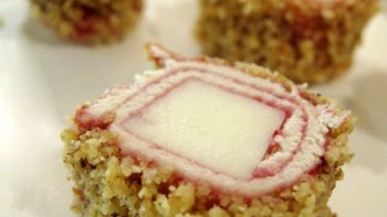 Pour 20 petits roulés - Préparation : 20 minutes - Cuisson : 5 minutes à 200°C. - INGRÉDIENTS : 4 tranches de pain de mie (sans la croûte) - 2 cuillères à soupe de confiture de cerise noires - 100 gr. de fromage de brebis basque - 100 gr. de cerneaux de noix.  - PRÉPARATION :  - Écraser les cerneaux de noix, les étaler sur la plaque du four et les torréfier à 200°C pendant 5 minutes. - Couper la croûte des tranches de pain demi et les aplatir à l'aide d'un rouleau à pâtisserie. le reste de la préparation en Image.