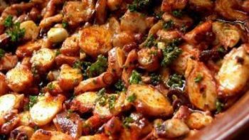 En Espagnol : Pulpo a la gallega, c'est un plat typyque et basique de la gastronomie régionale. Il est cuit entier dans des chaudrons en cuivre et servi dans des assiettes en bois.